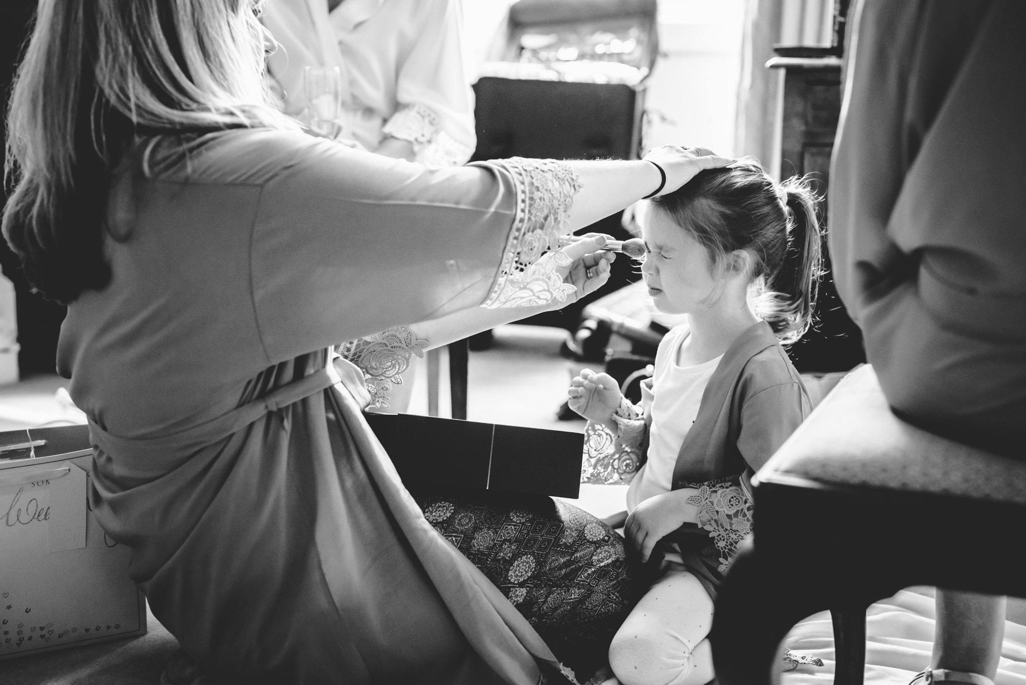 A flower girl having her hair styled for a wedding 