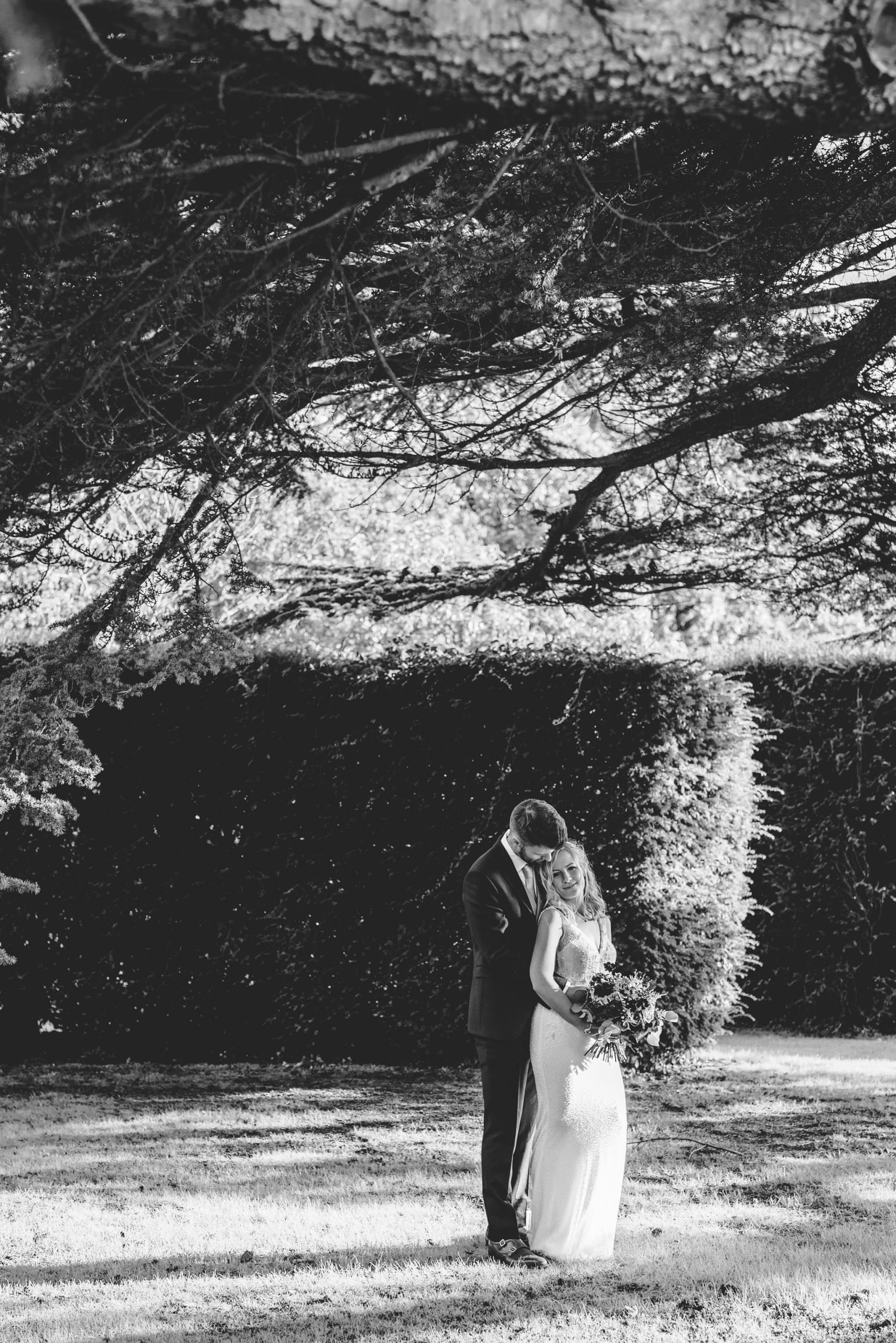 A black and white picture of a bride andgroom cuddling at Brinsop Court