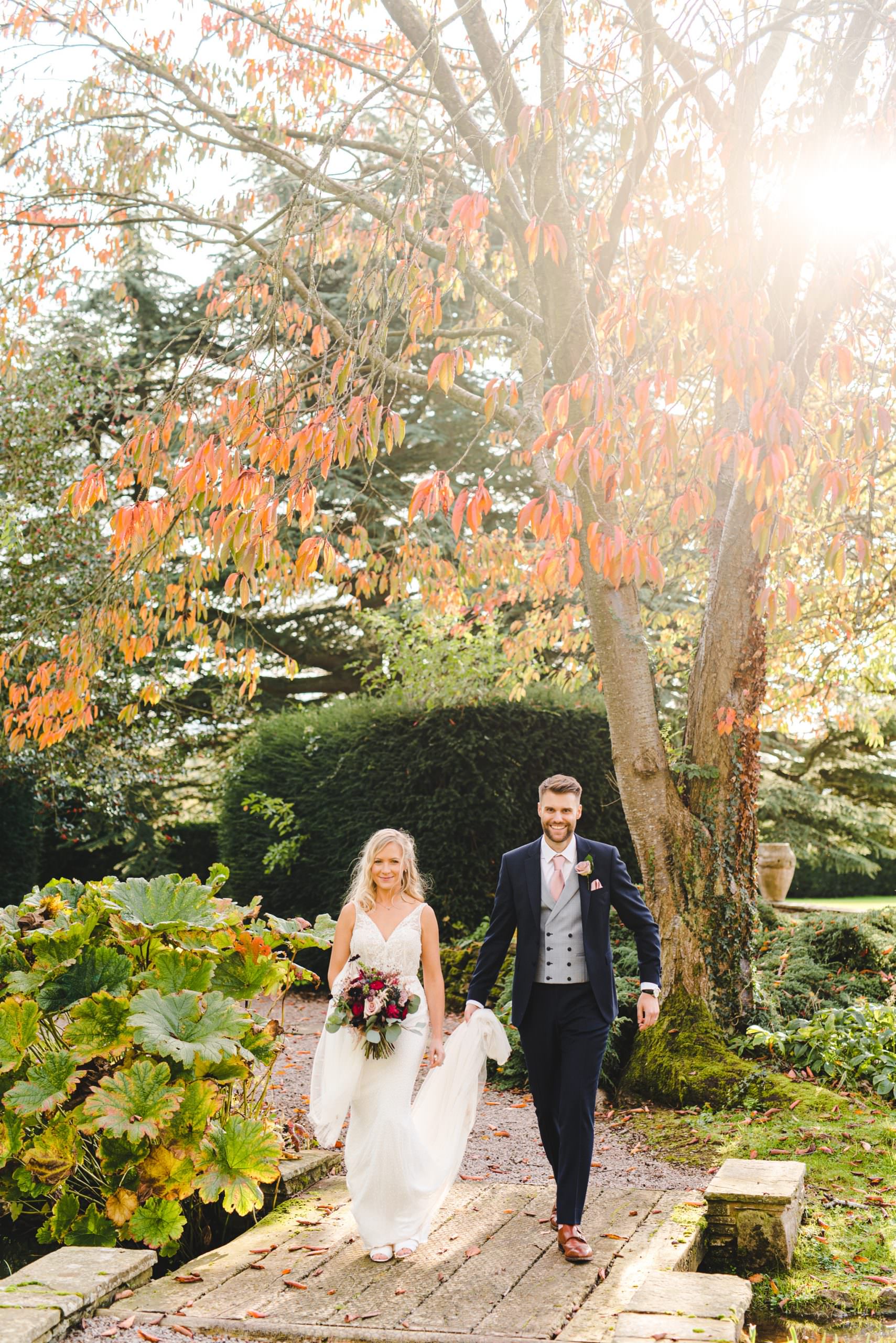 A bride and groom walking in the grounds at Brinsop Court