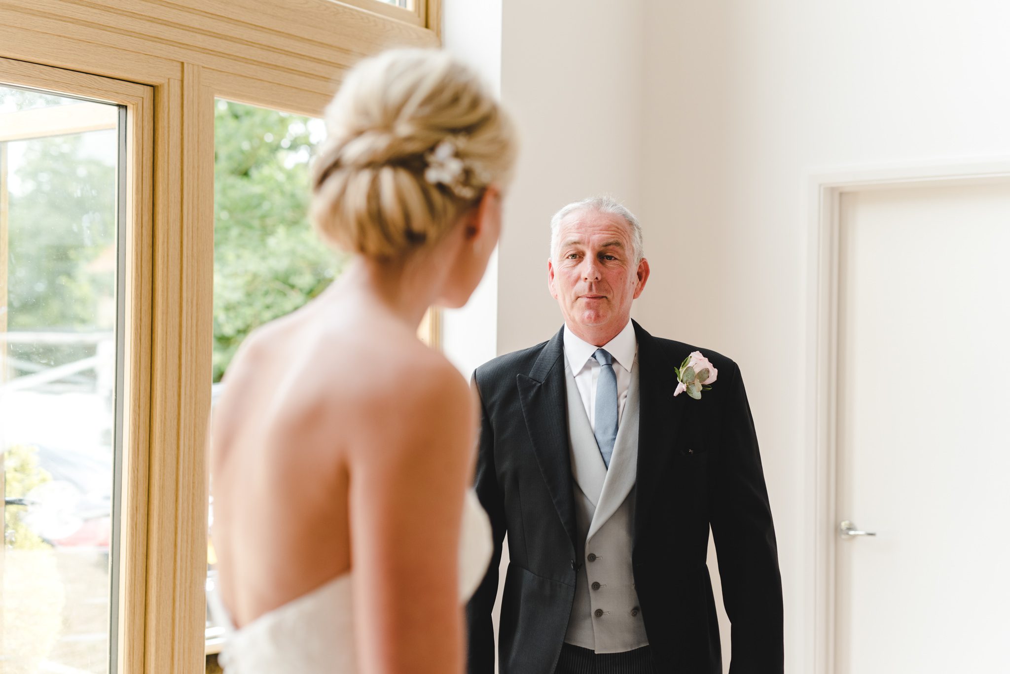A father seeing his daughter in her wedding dress for the first time