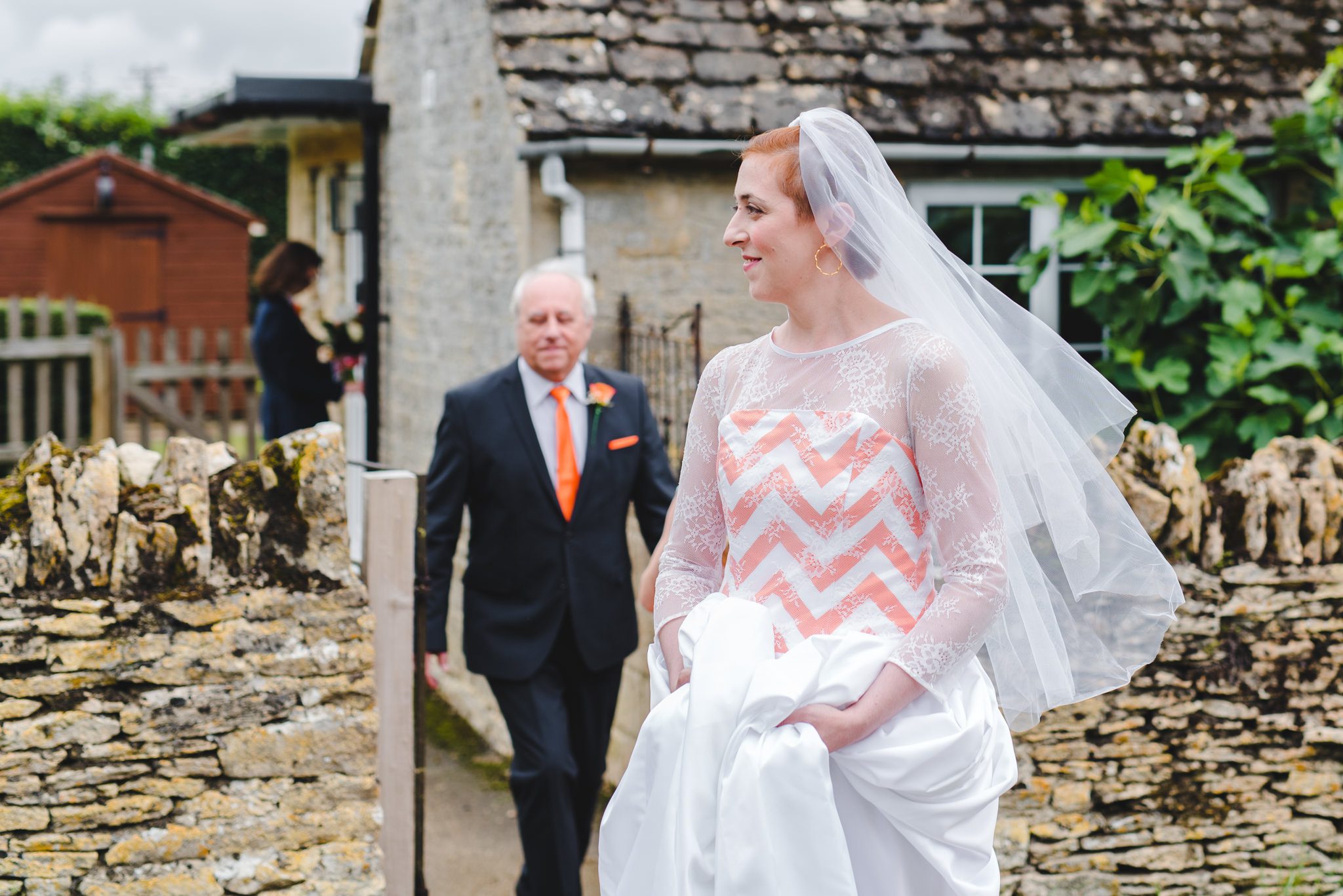 A bride walking to her wedding ceremony from teh cottage at Oxleaze
