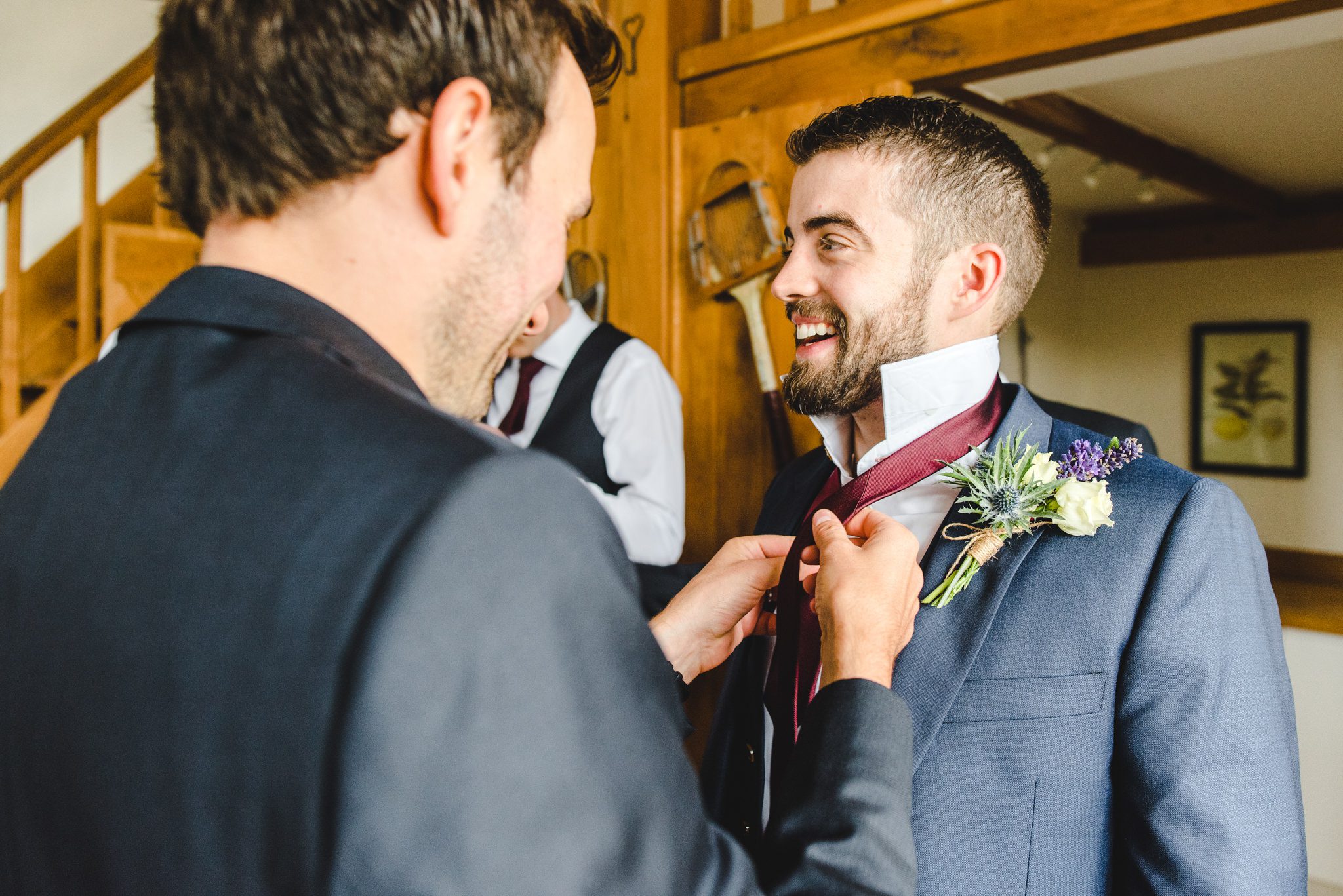 Agroomsman attaching the groom's buttonhole at a Merriscourt wedding