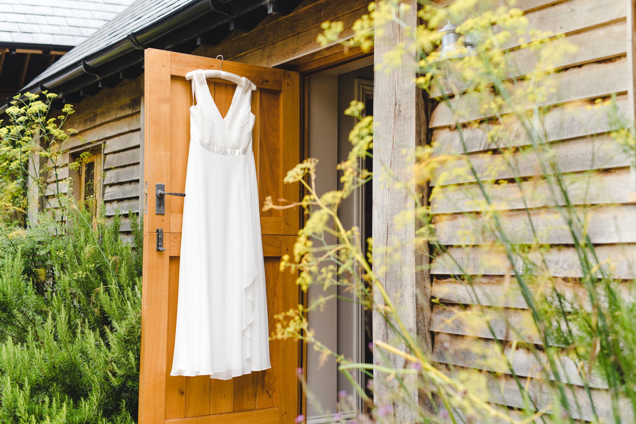 A wedding dress hanging on the door of the bridal suite at Upcote