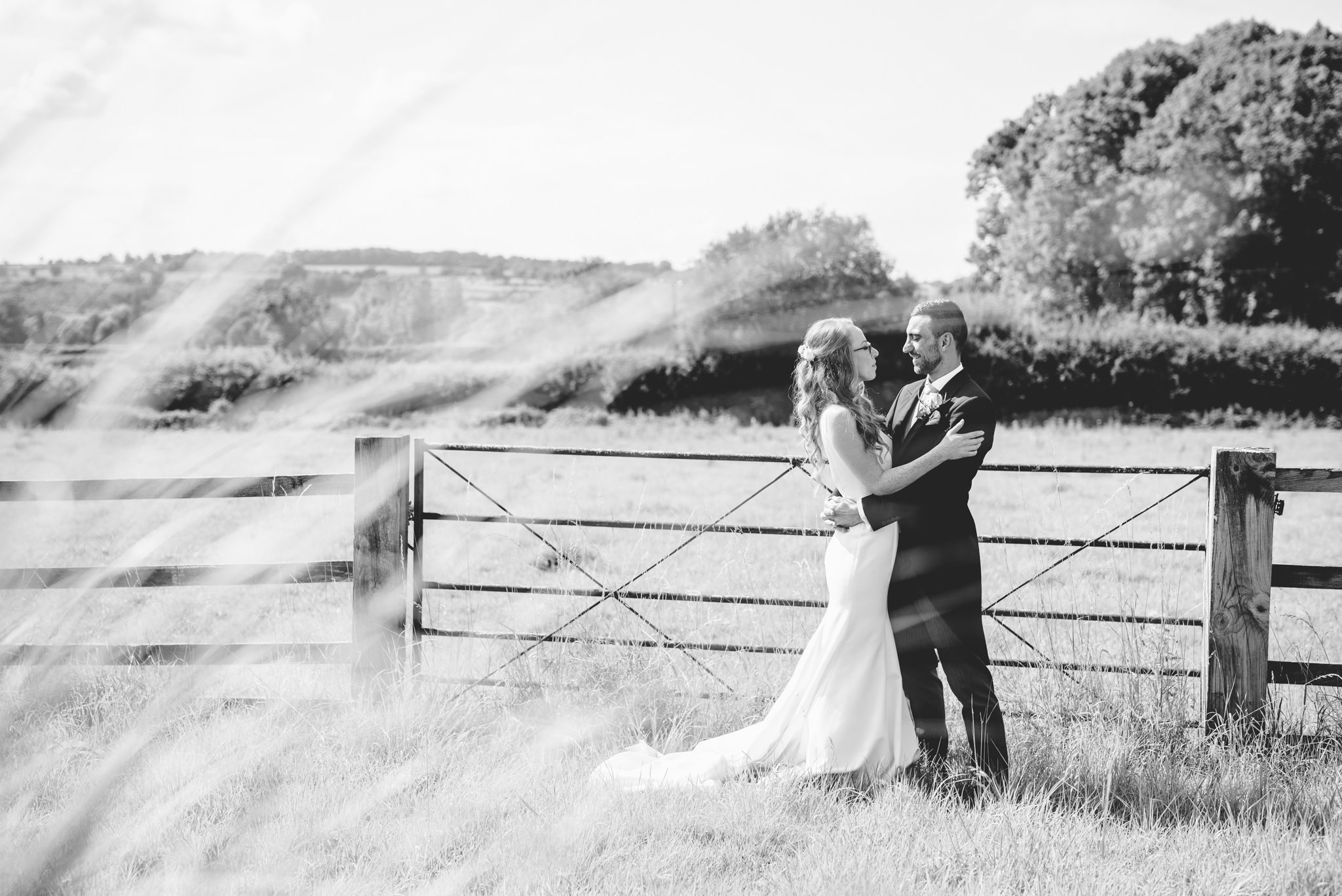 A bride and groom walking in the fields at sunset at Hyde House