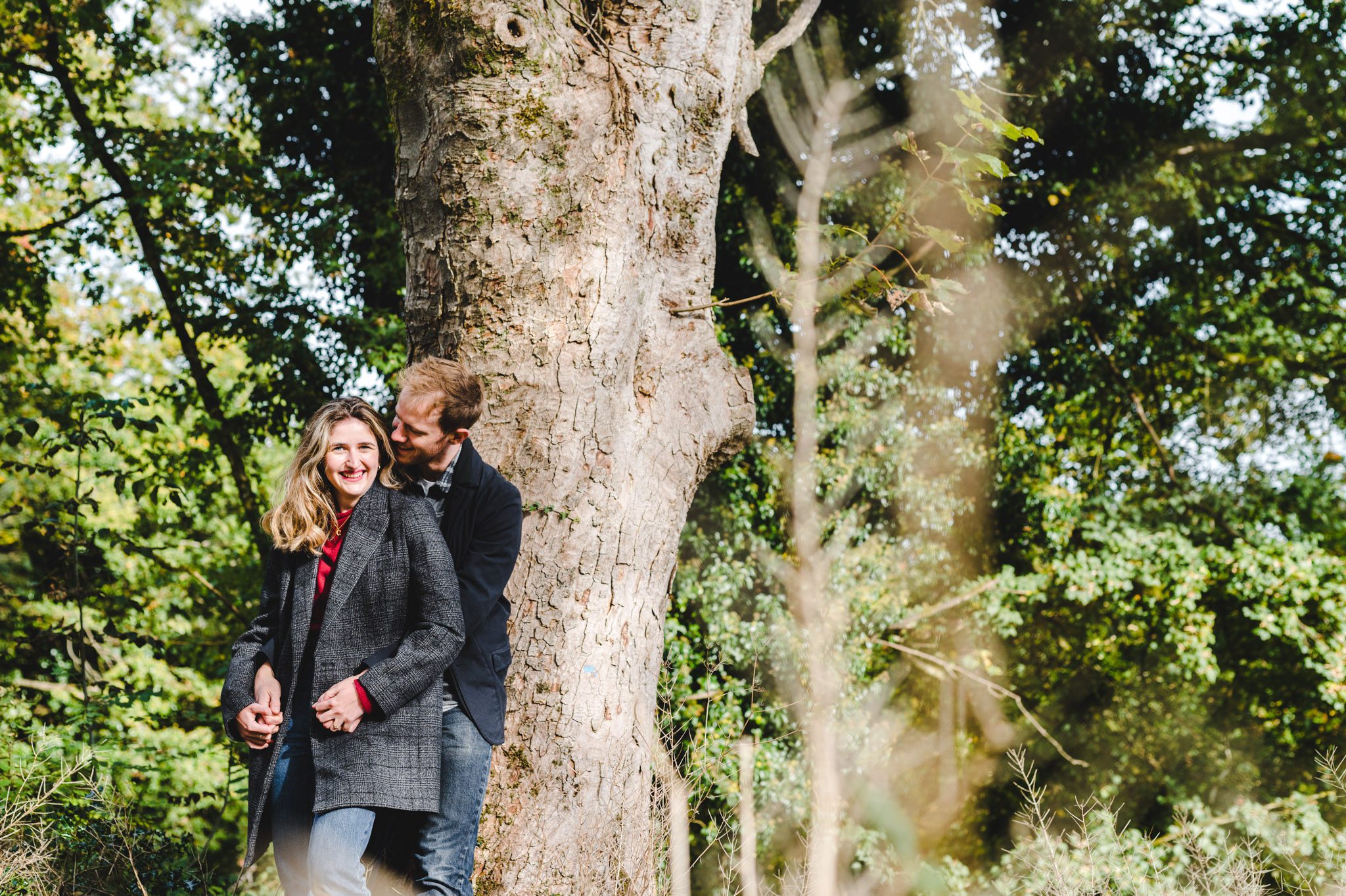 A couple hugging by a tree in Gloucestershire