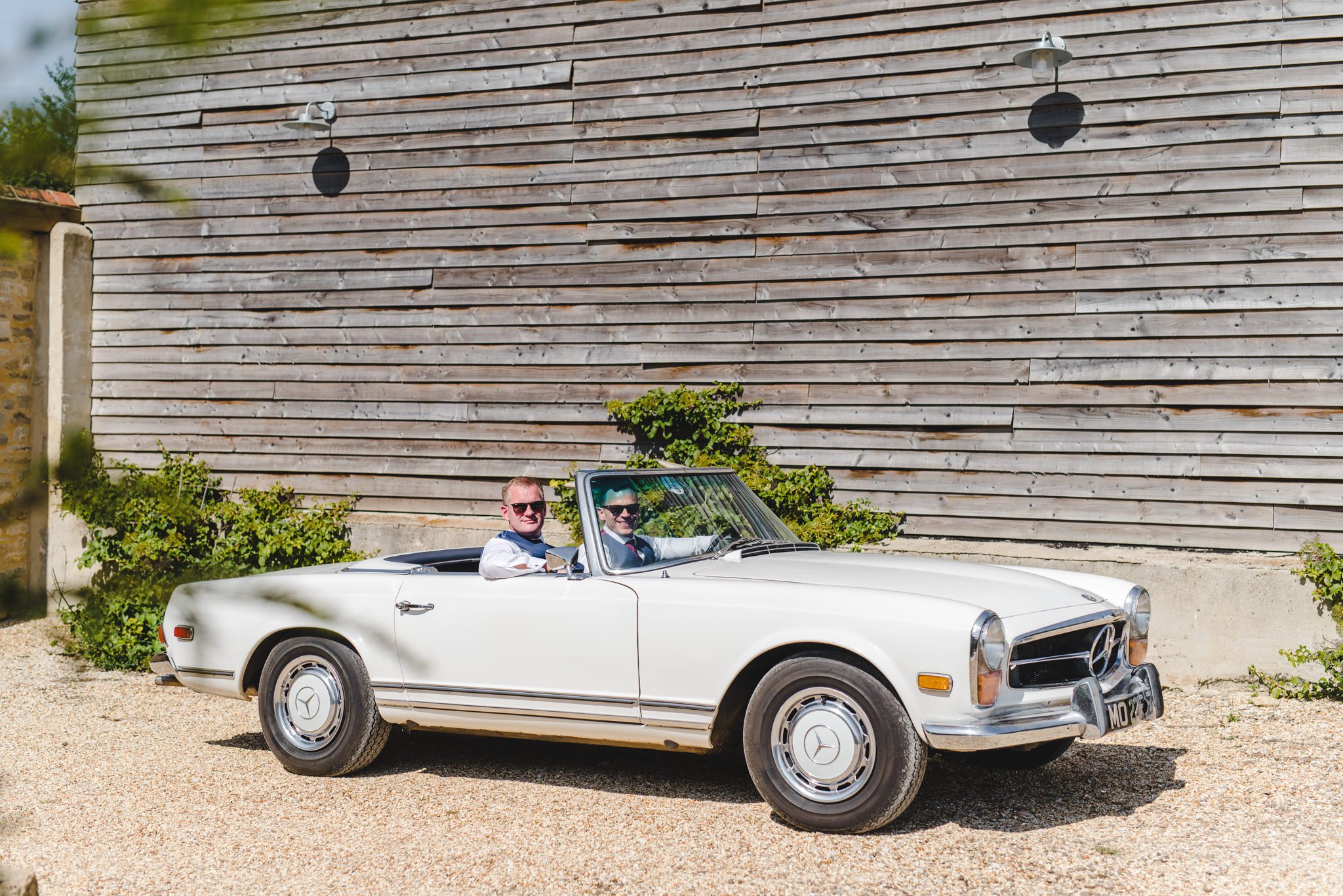 Groom in a drop top Mercedes