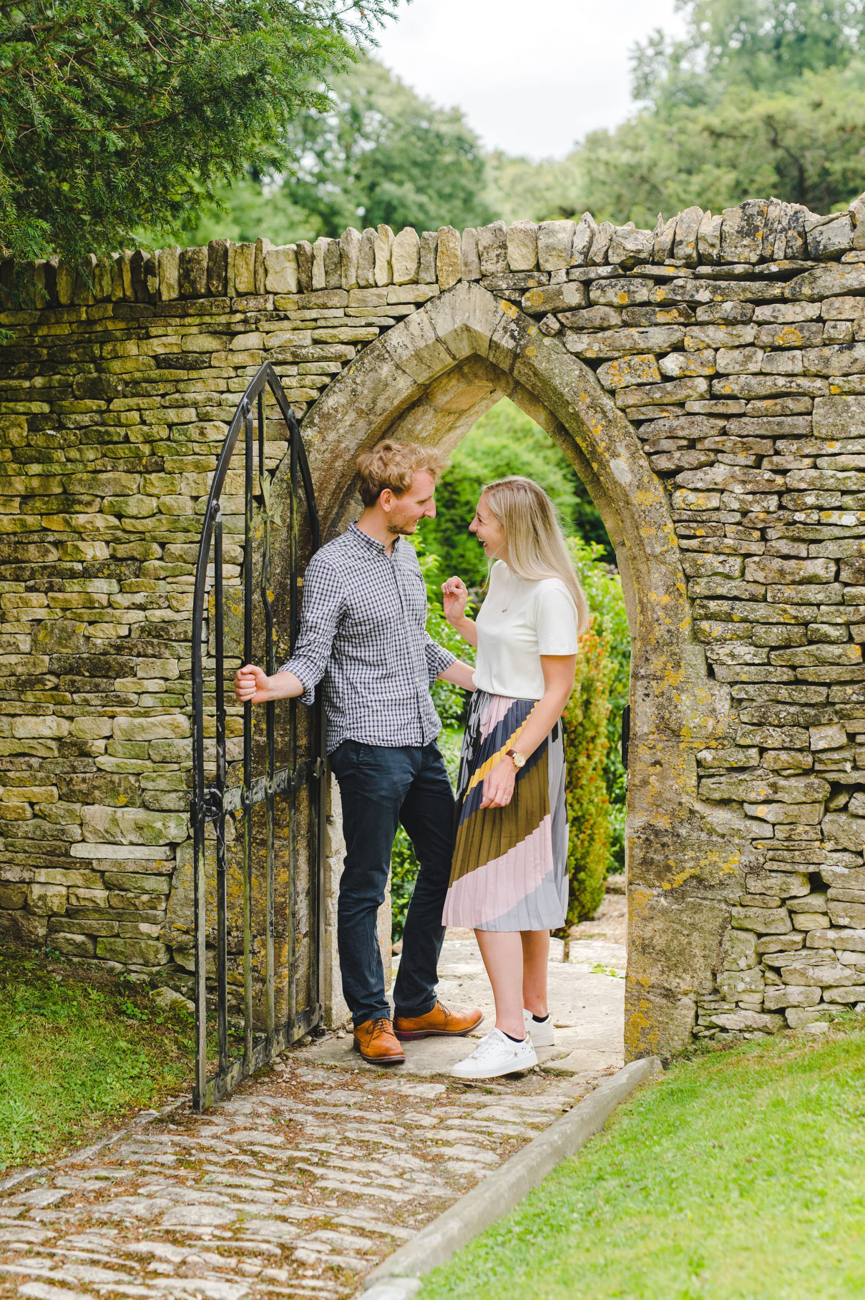 A couple standing in an archway by a church