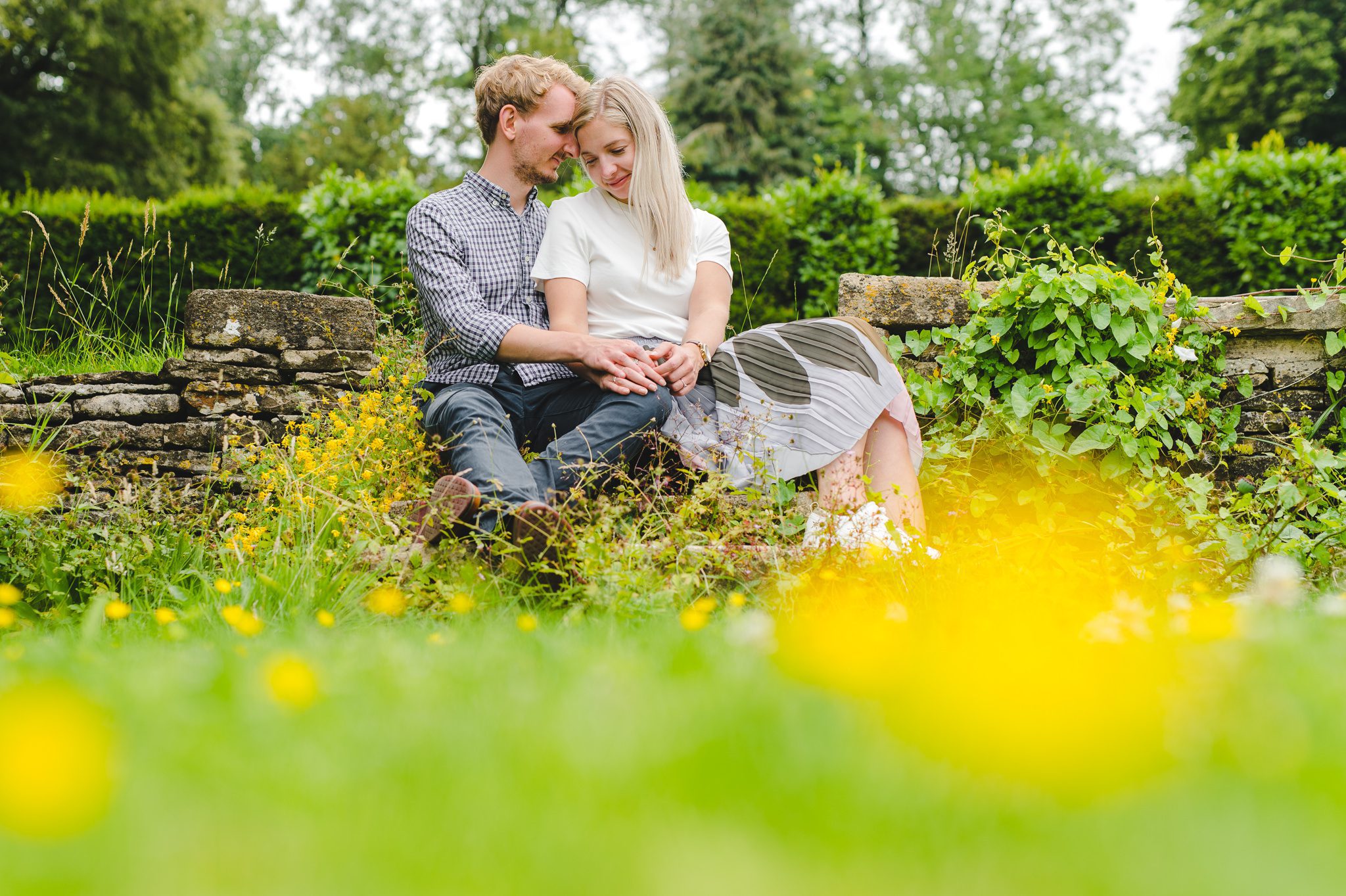 A couple sat on some steps near some buttercups