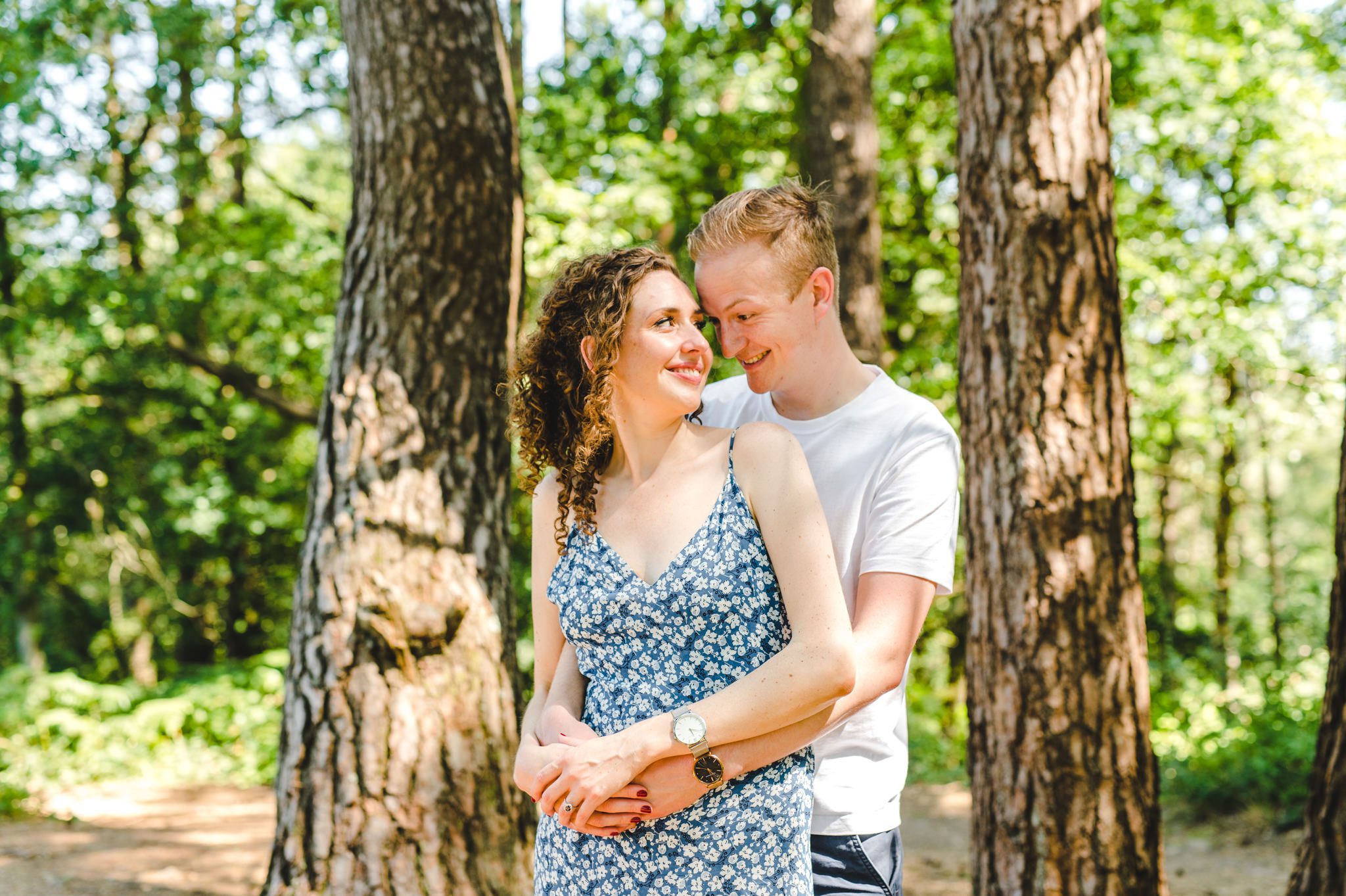A man and woman smiling on their surrey engagement shoot