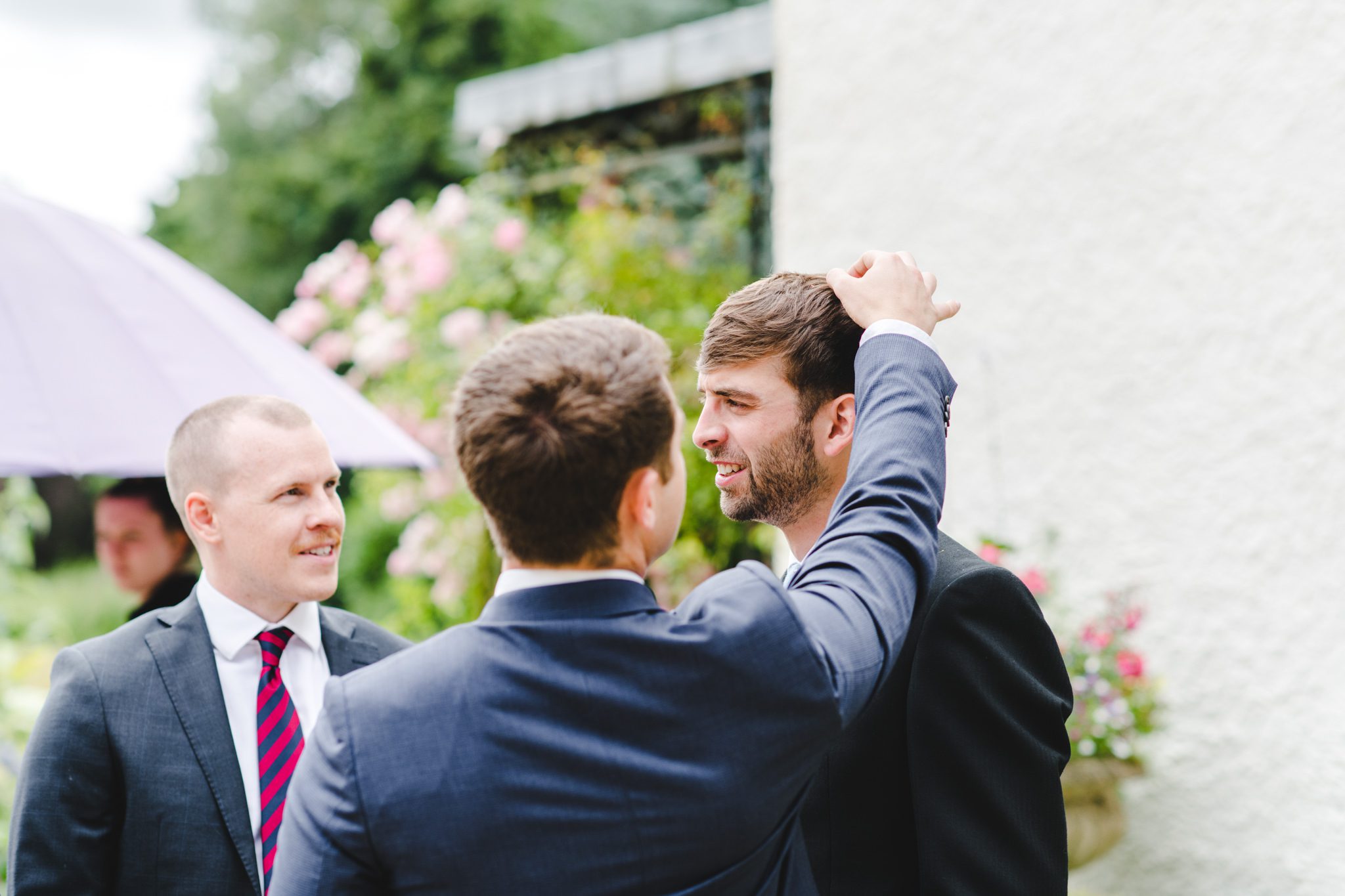 A wedding guest picking confetti out of a grooms hair