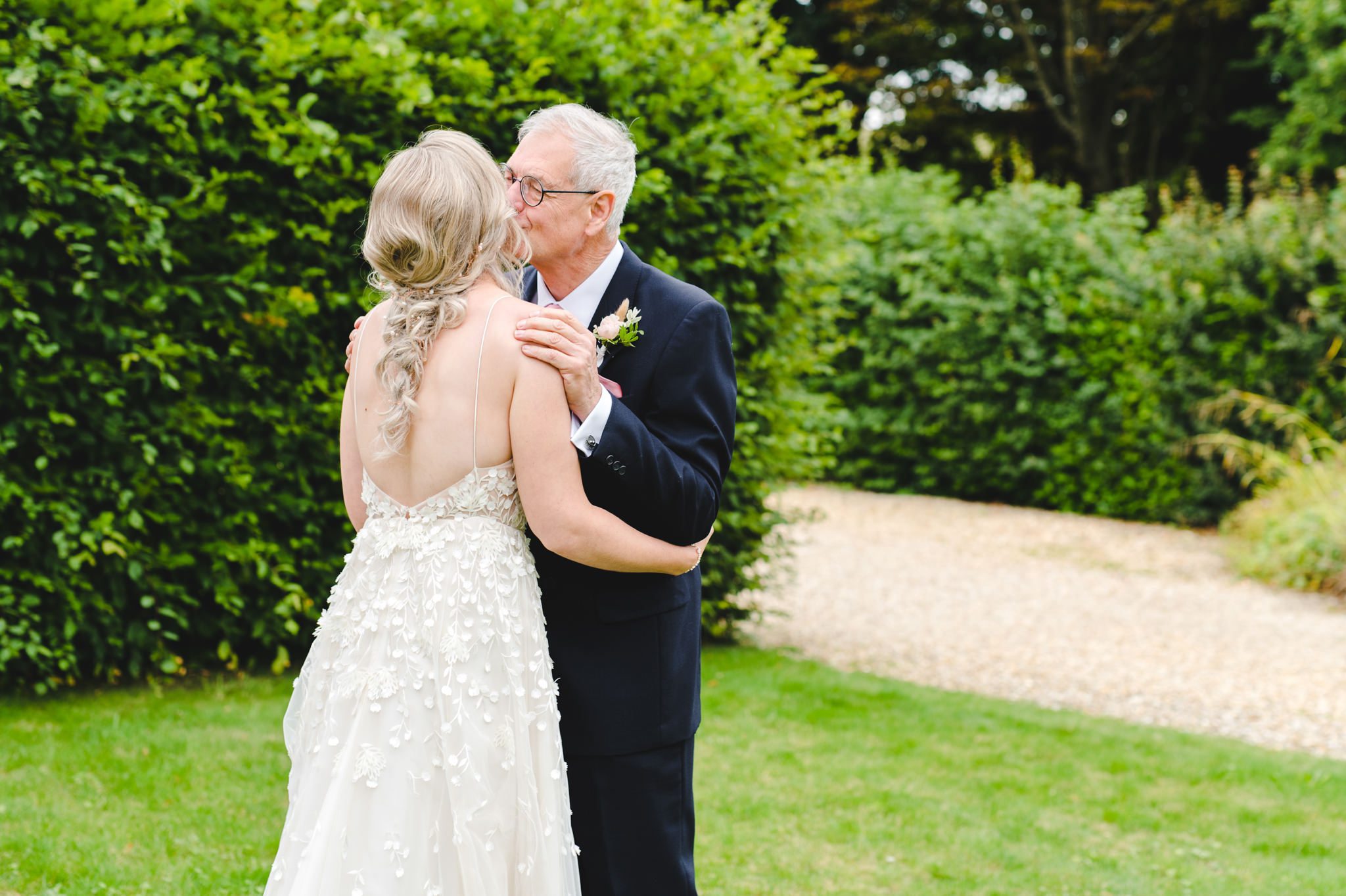A bride's father kissing his daughter