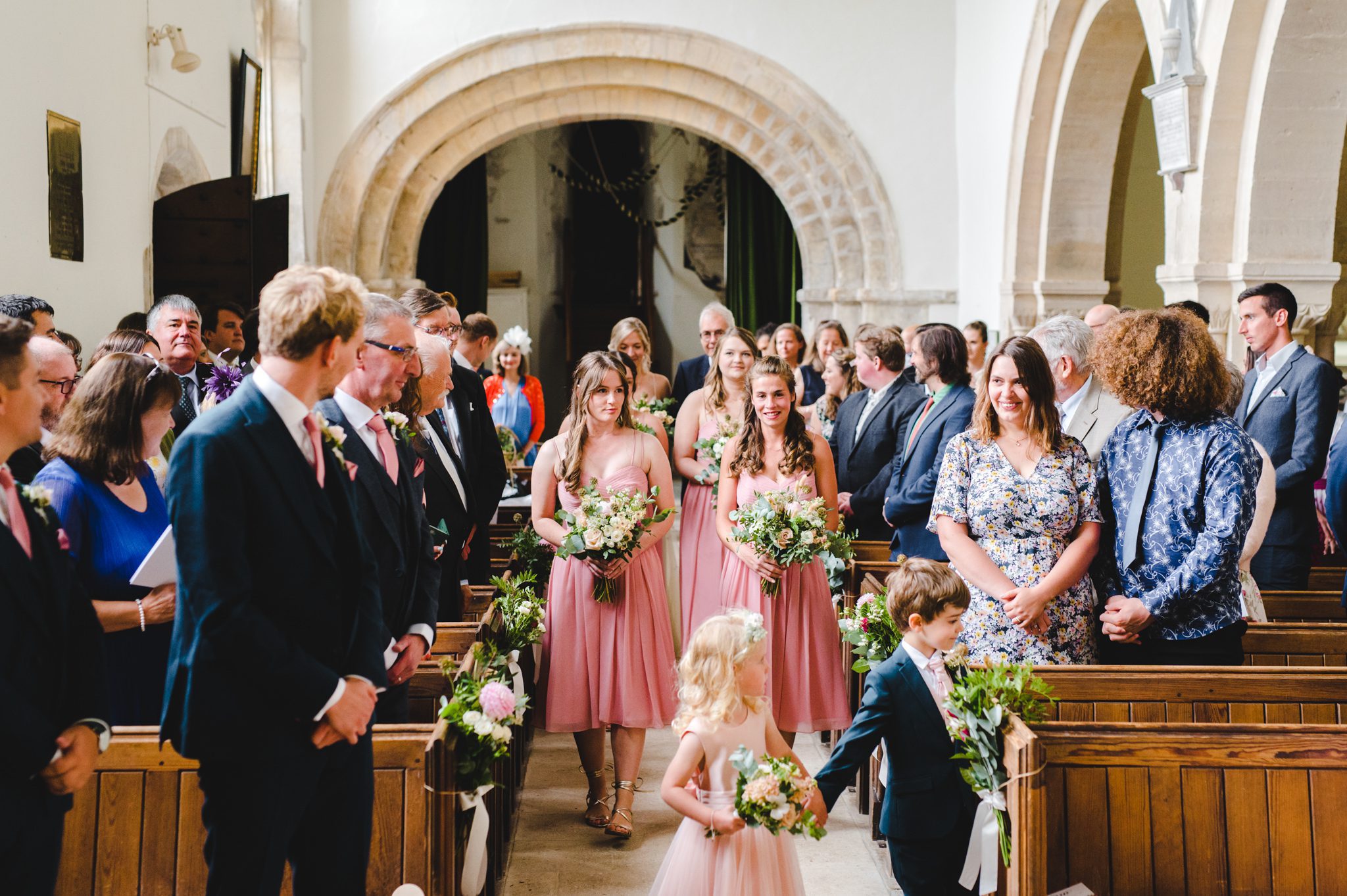 Bridesmaids walking down the aisle at Chedworth church