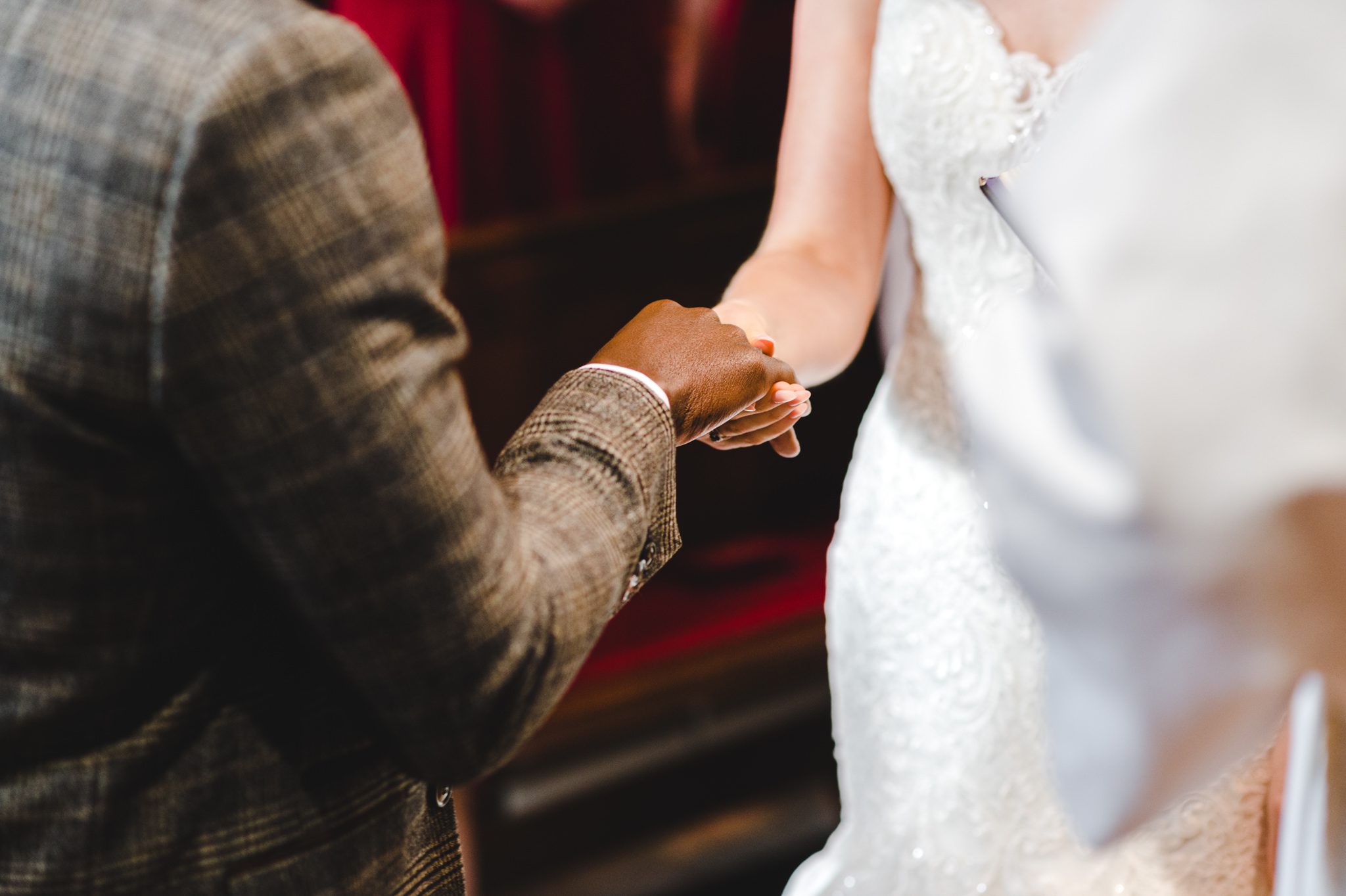 A close up of a bride and grooms hands