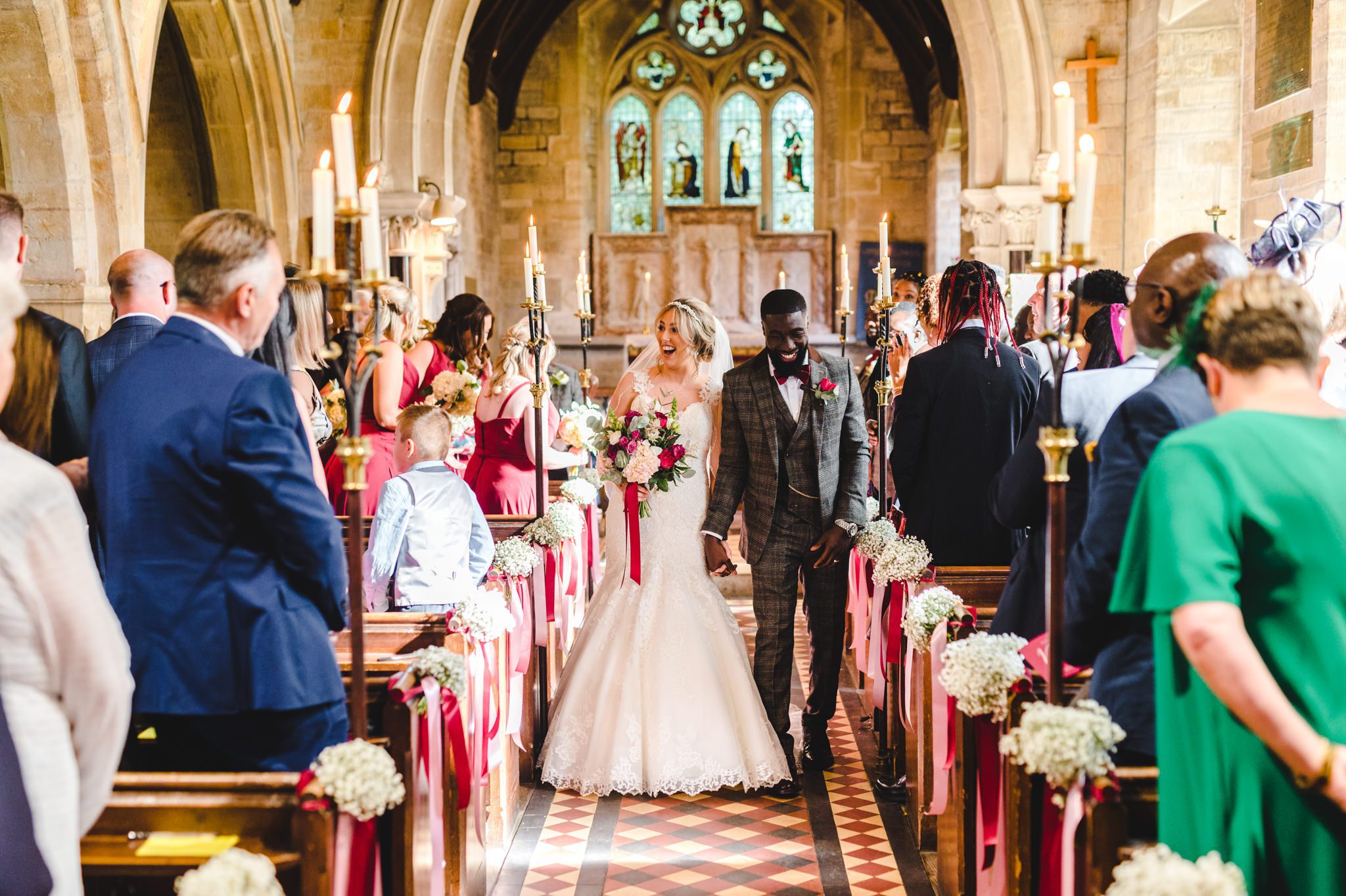 A newly married bride and groom walking back down the aisle