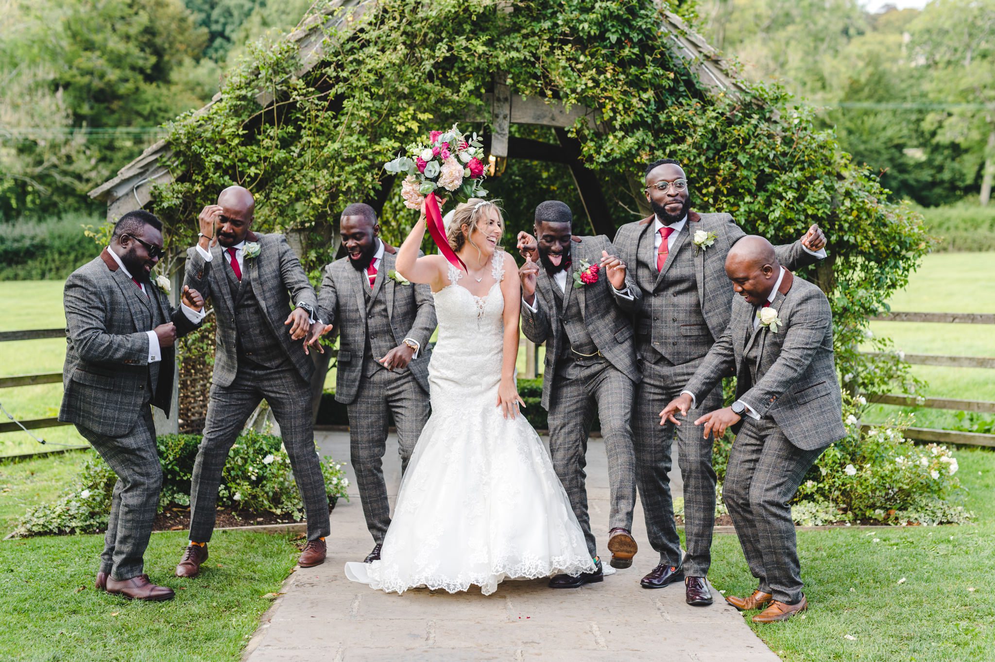 Bride and groomsmen dancing during group pictures