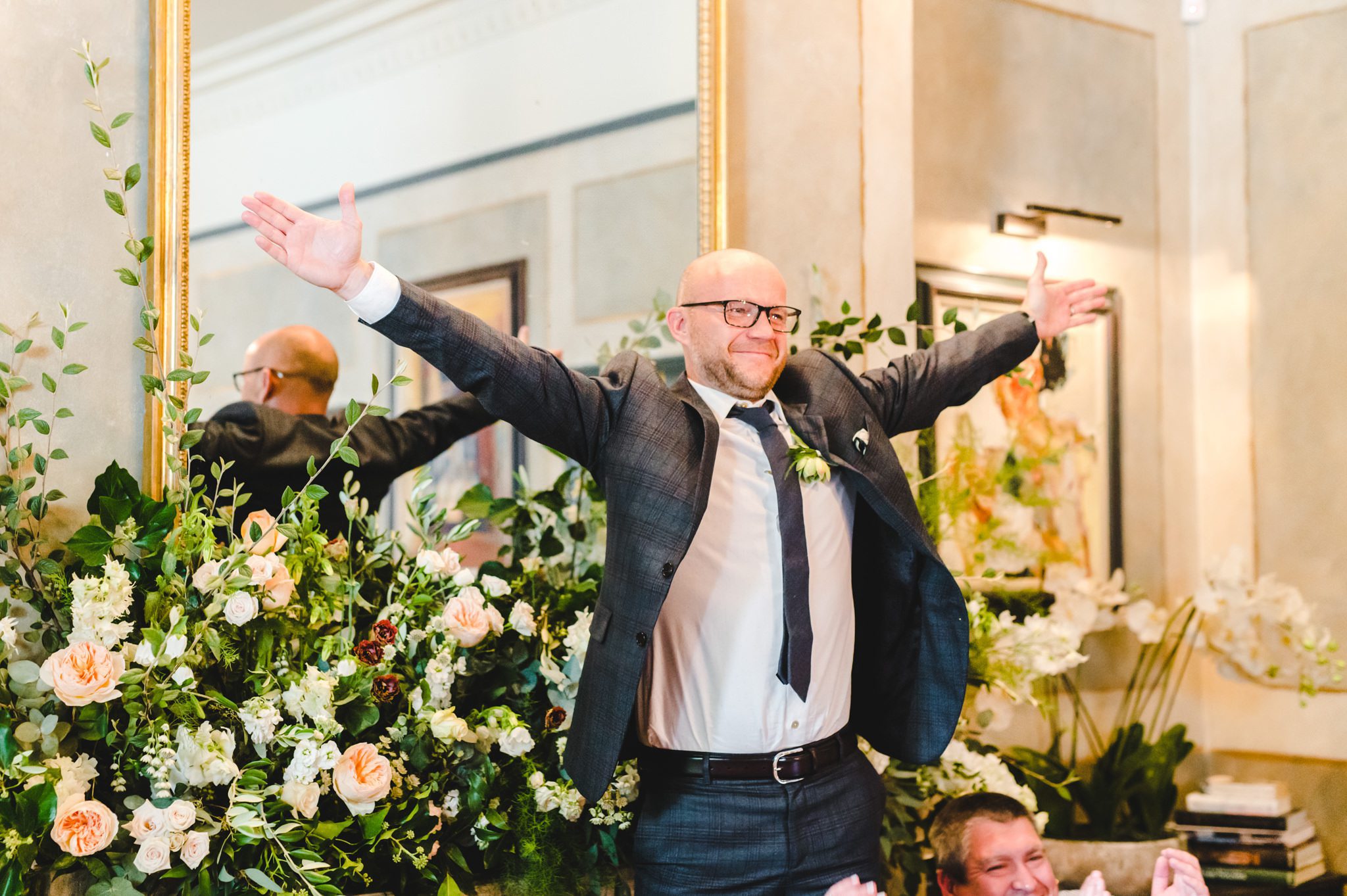 A groom standing up with his arms out
