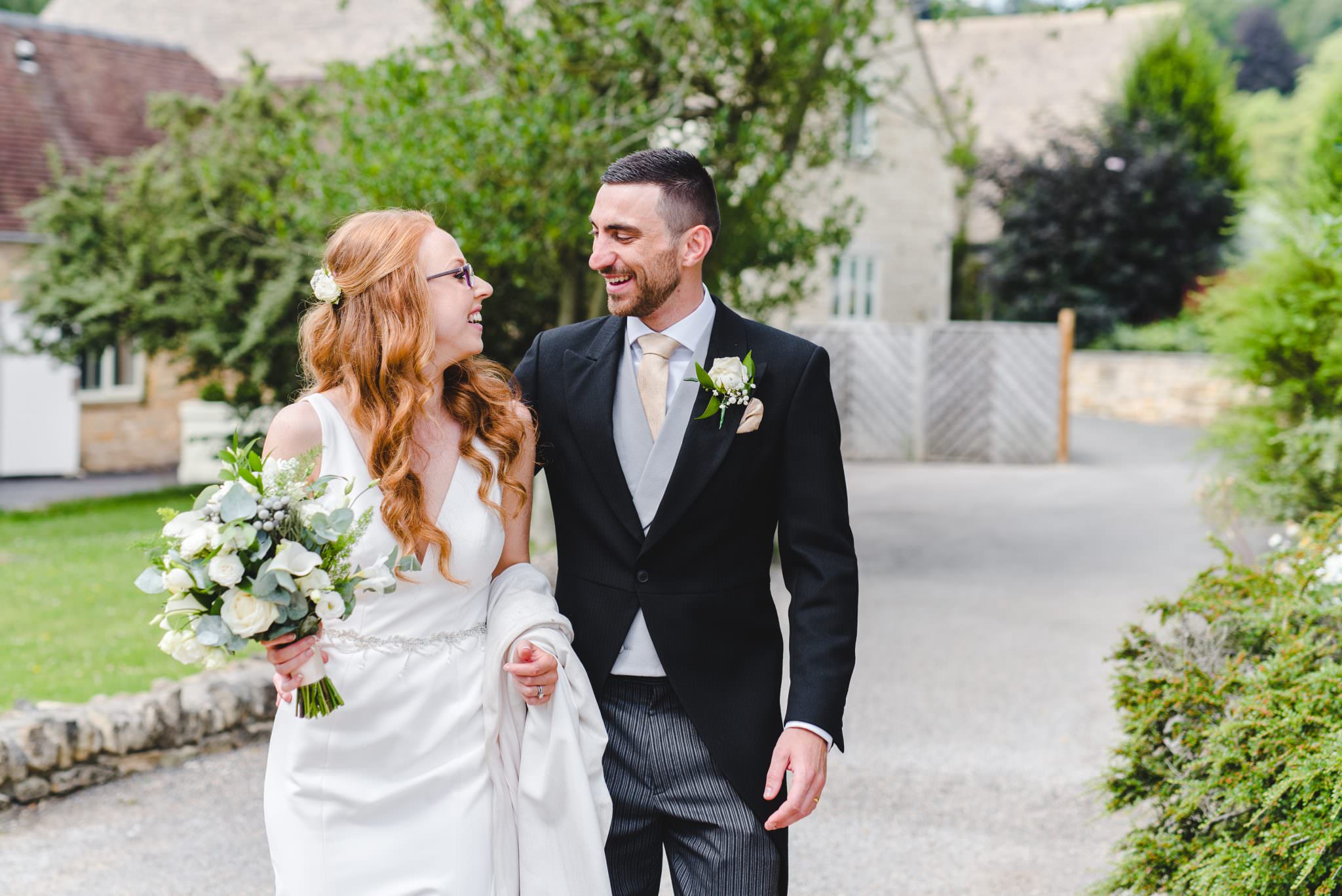 A redhead bride and a dark haired groom walking together at Hyde House
