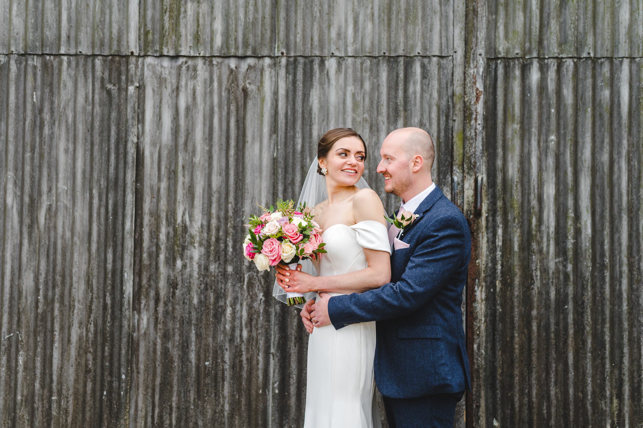 An elmore court couple standing against a metal wall