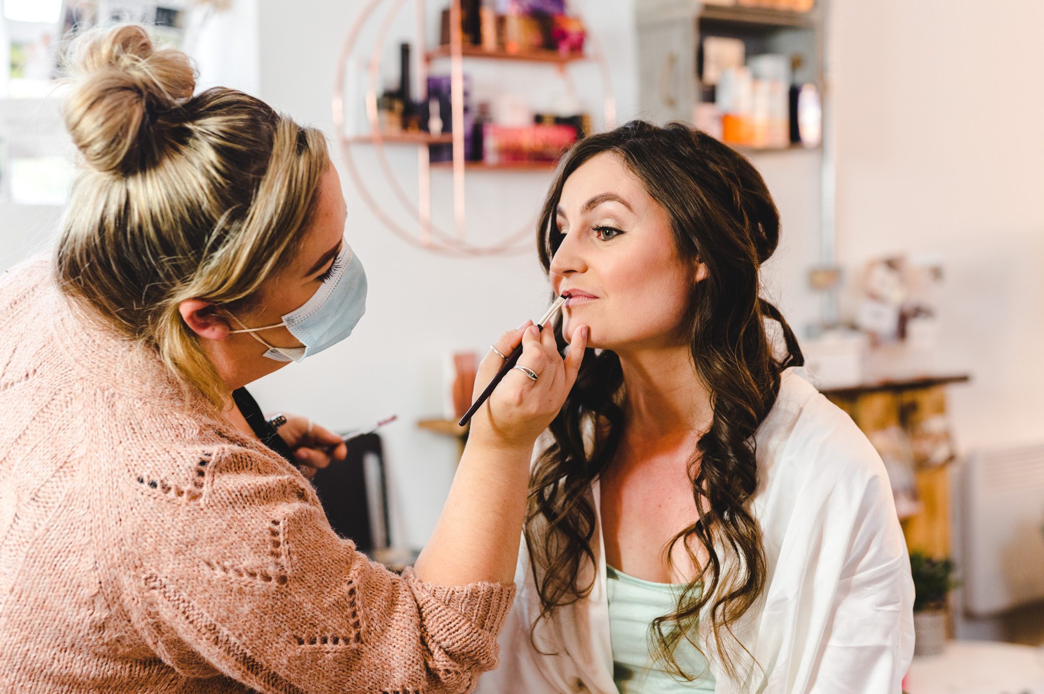 make up by sandie putting lipstick on a bride