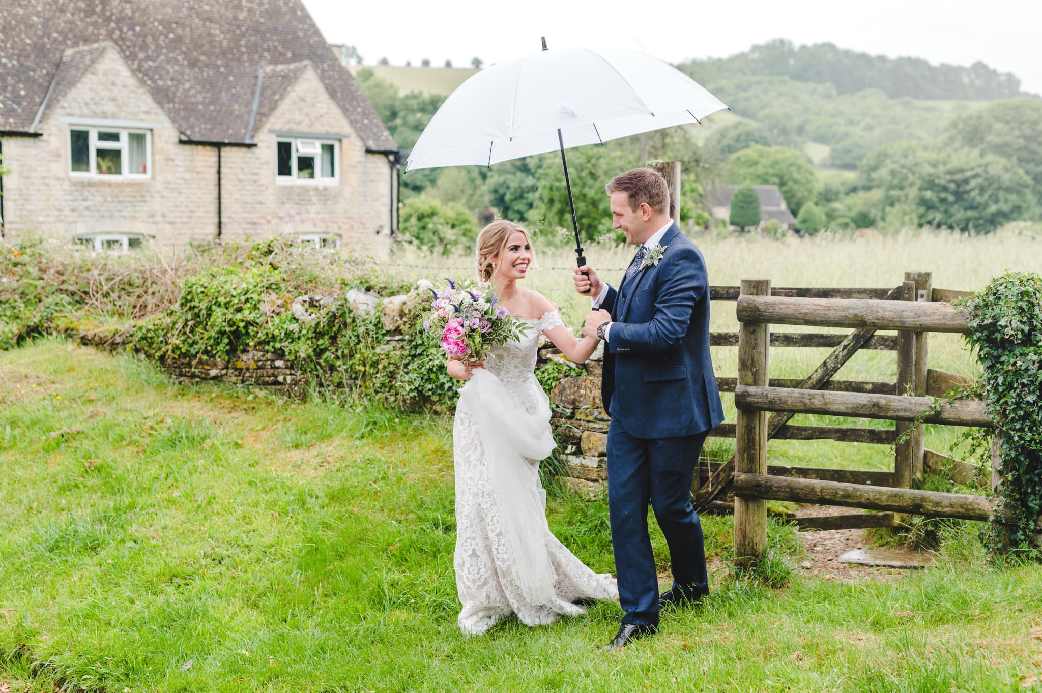 A bride and groom standing under an umbrella