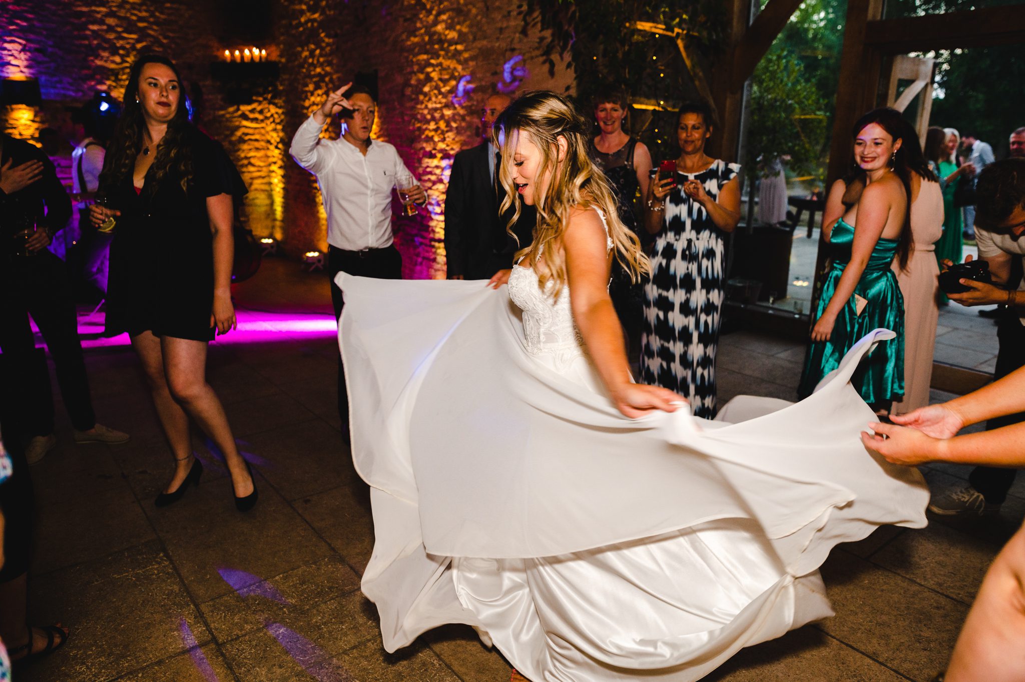 bride swishing her wedding dress on the dancefloor at Stone Barn