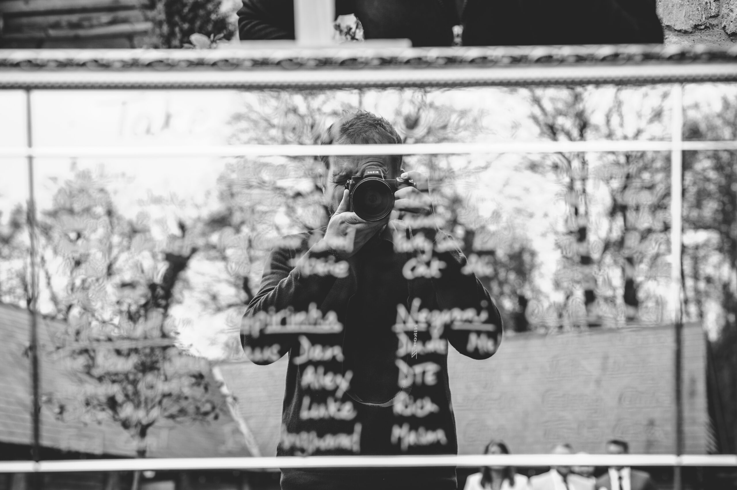 A man holding a camera at a wedding in the Cotswolds.