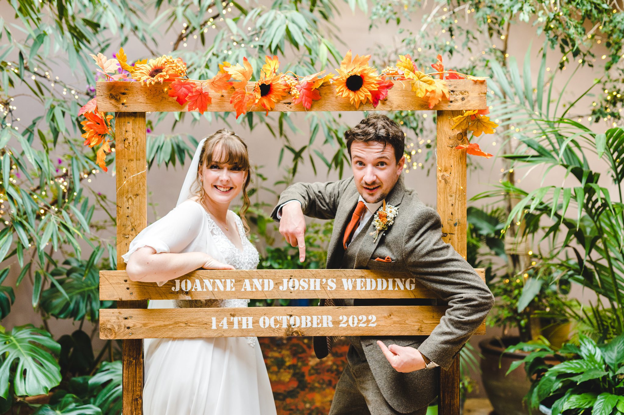 A couple posing in front of their wedding sign
