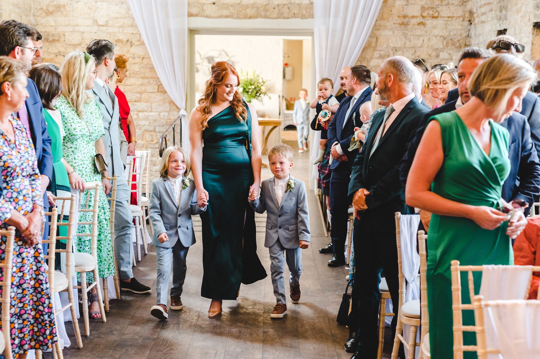 bridesmaids and page boys walking down the aisle