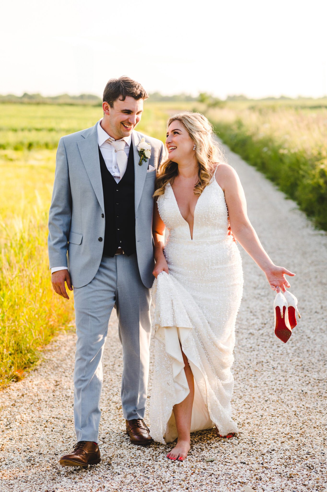 a bride and groom walking in the field at lapstone