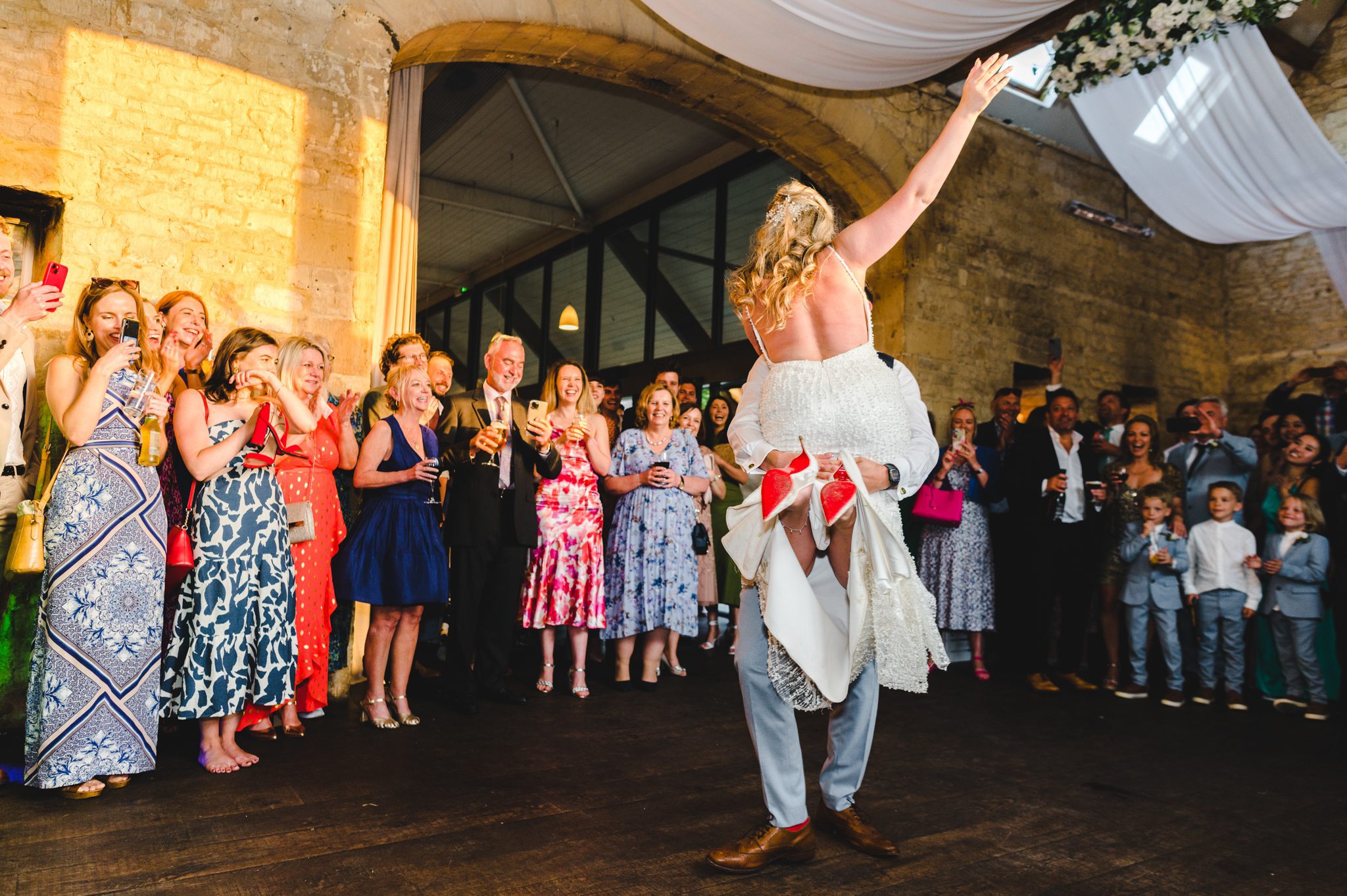 a groom lifting his bride up during their first dance