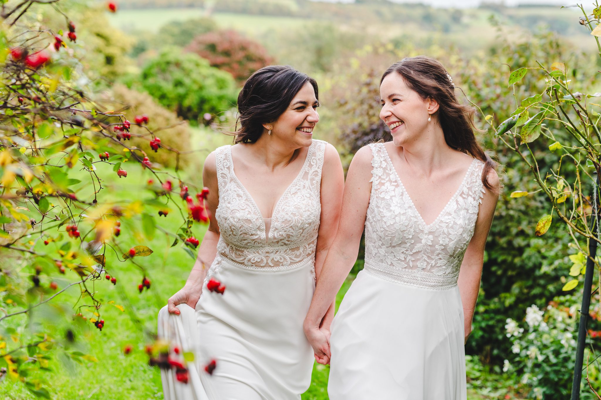 Two women married at Upcote barn surrounded by red berries and green fields