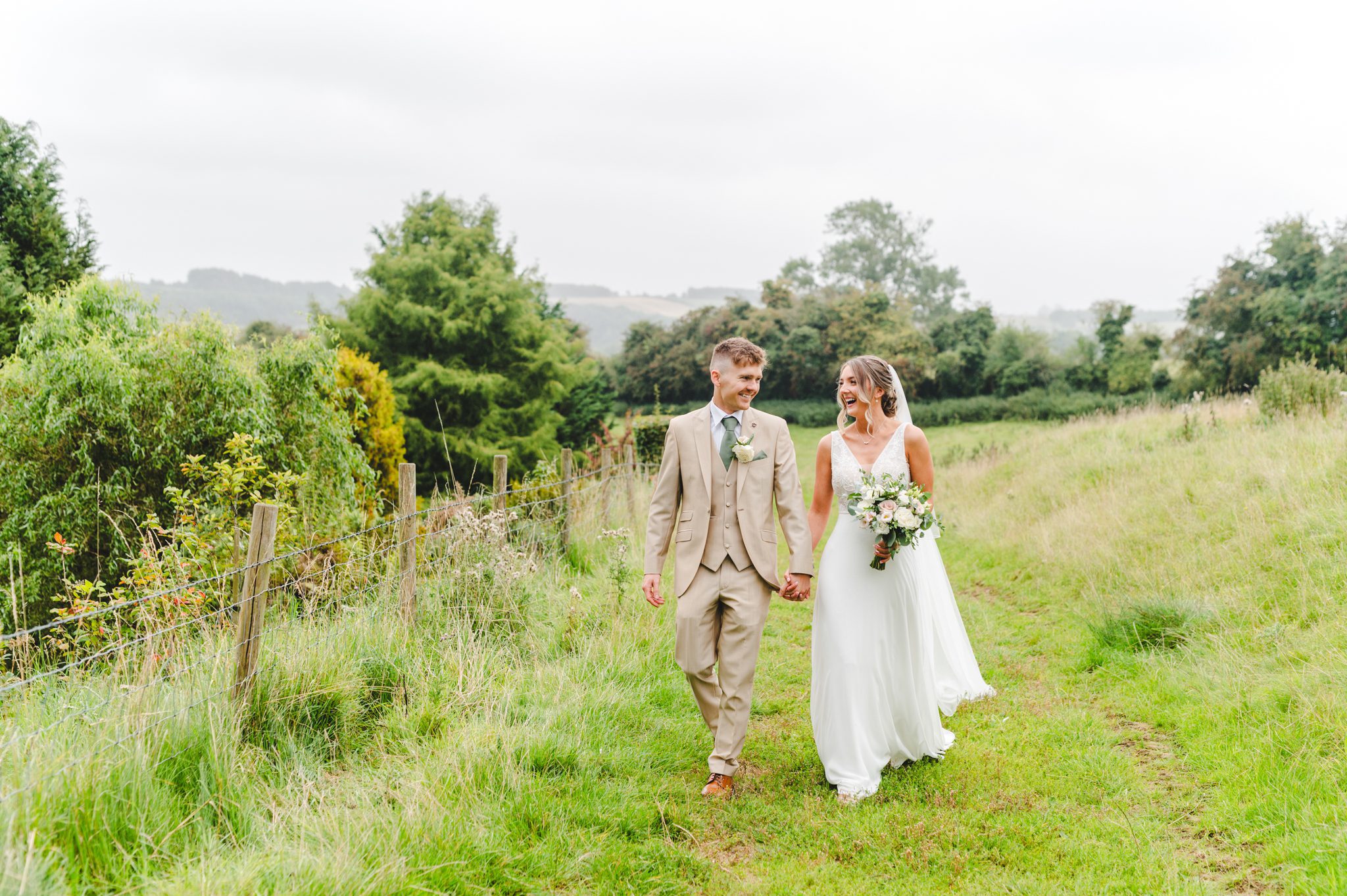 A couple at Upcote Barn walking in the fields