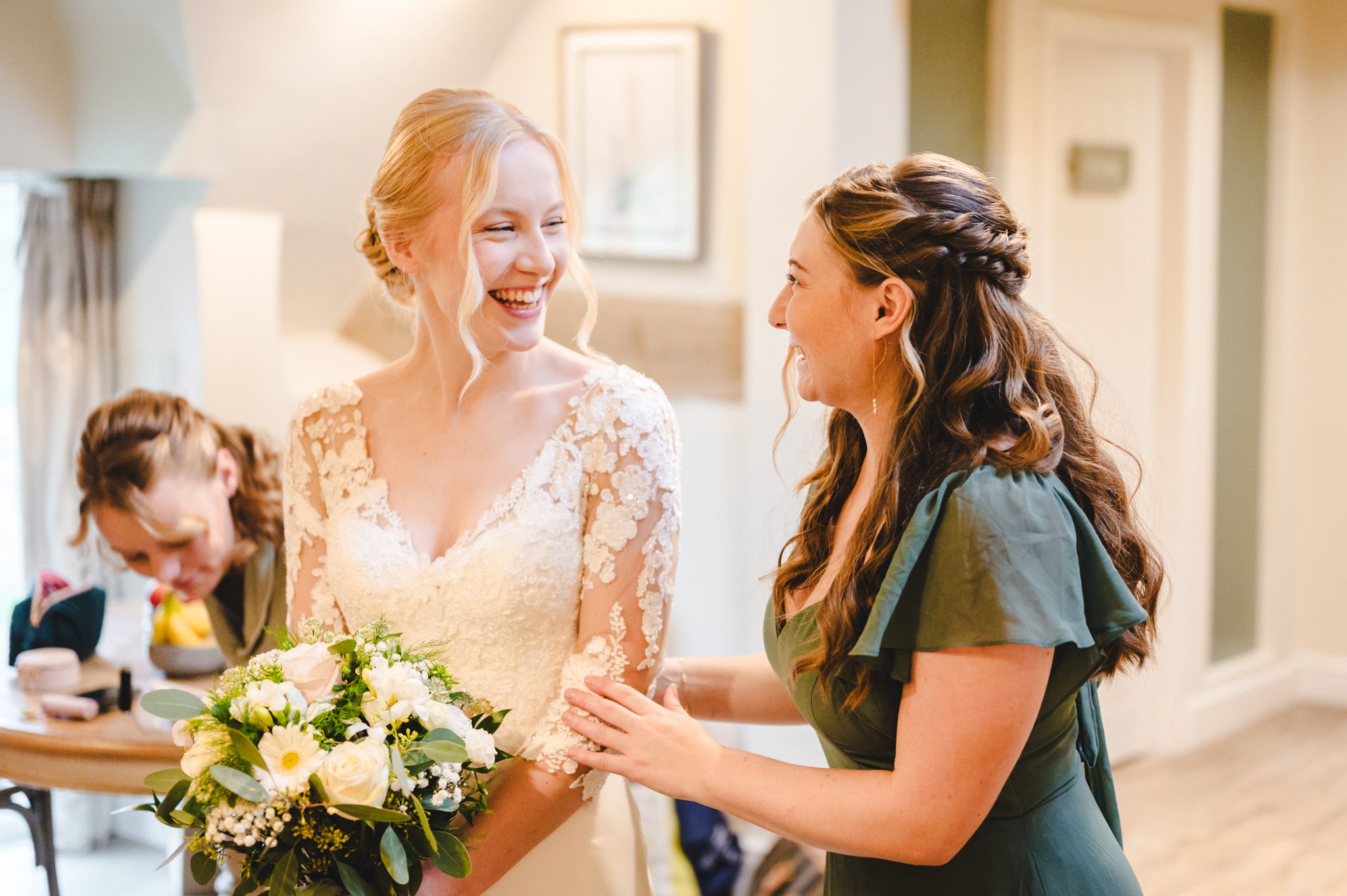 a woman in a white dress smiling with another woman in a green dress