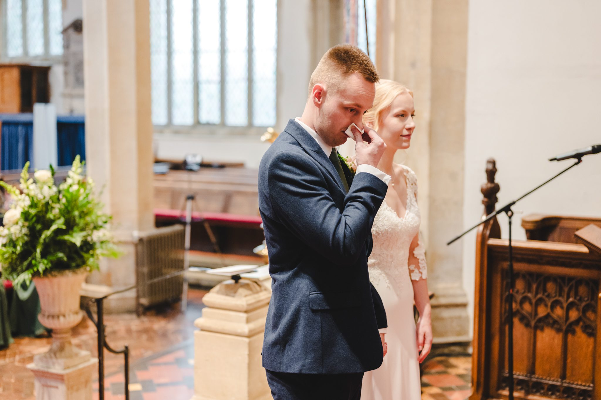 a man in a suit and tie standing next to a woman in a church