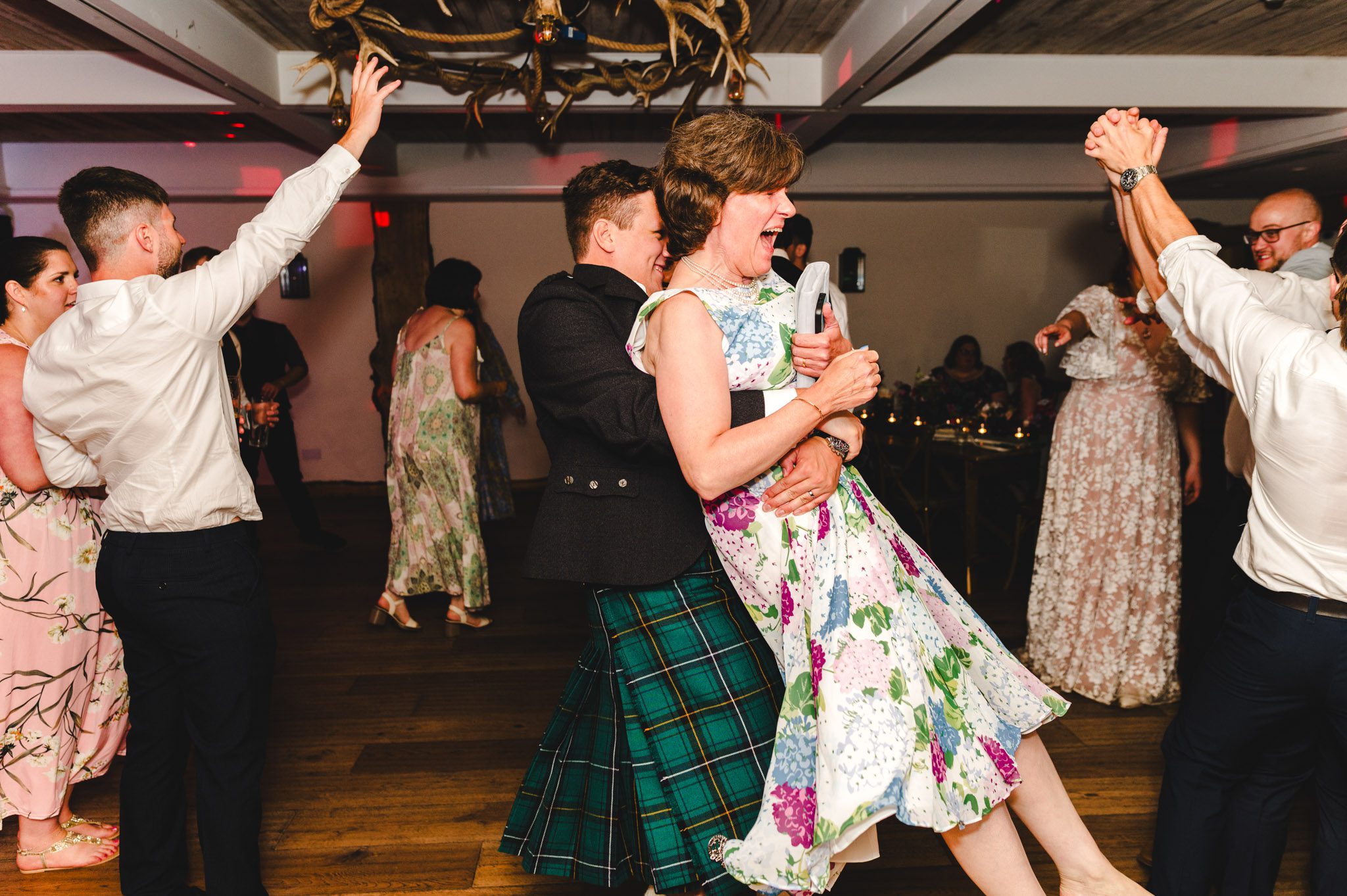 A groom lifting his mum up during a wedding