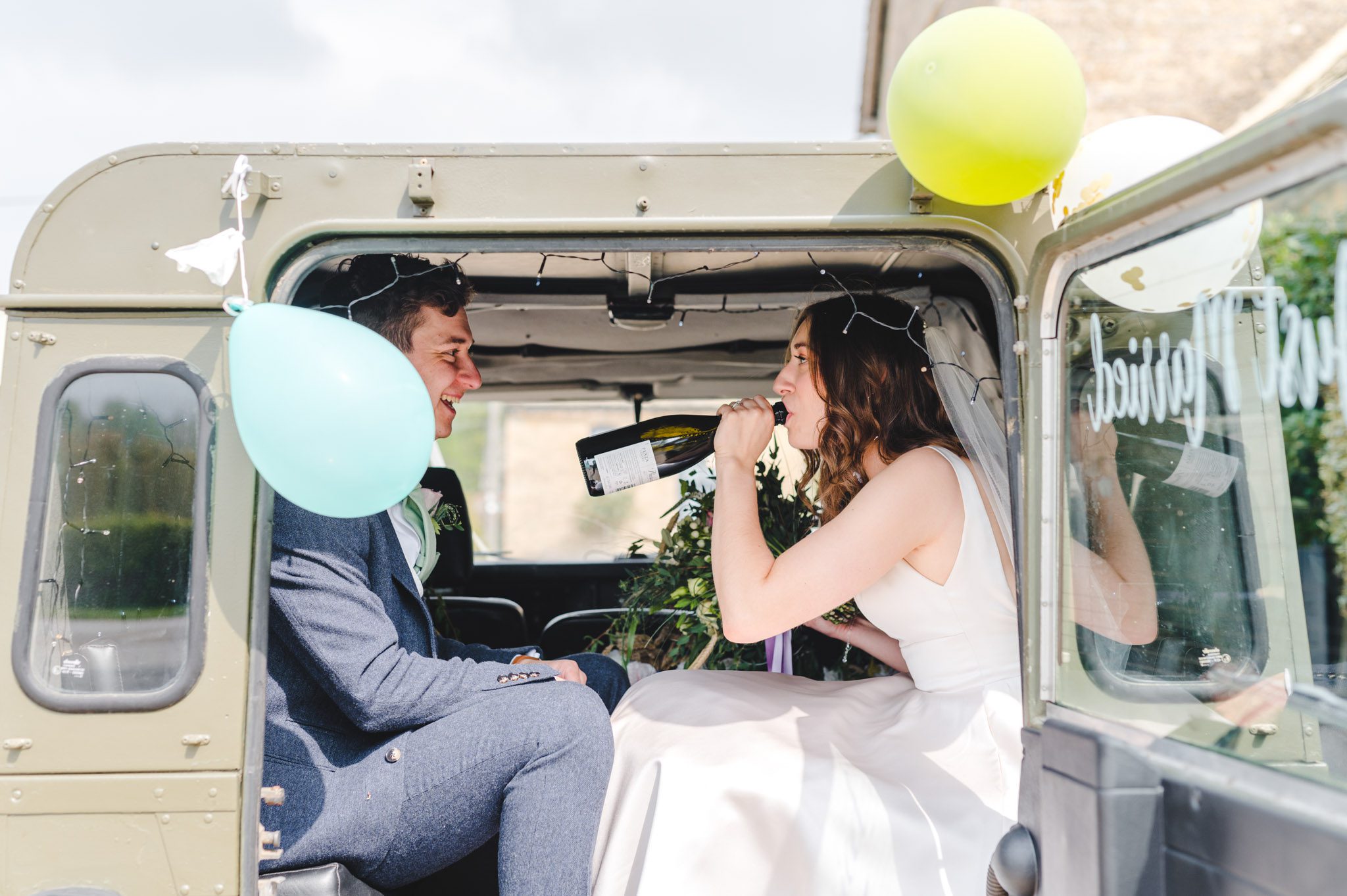 A bride drinking from a bottle of champagne