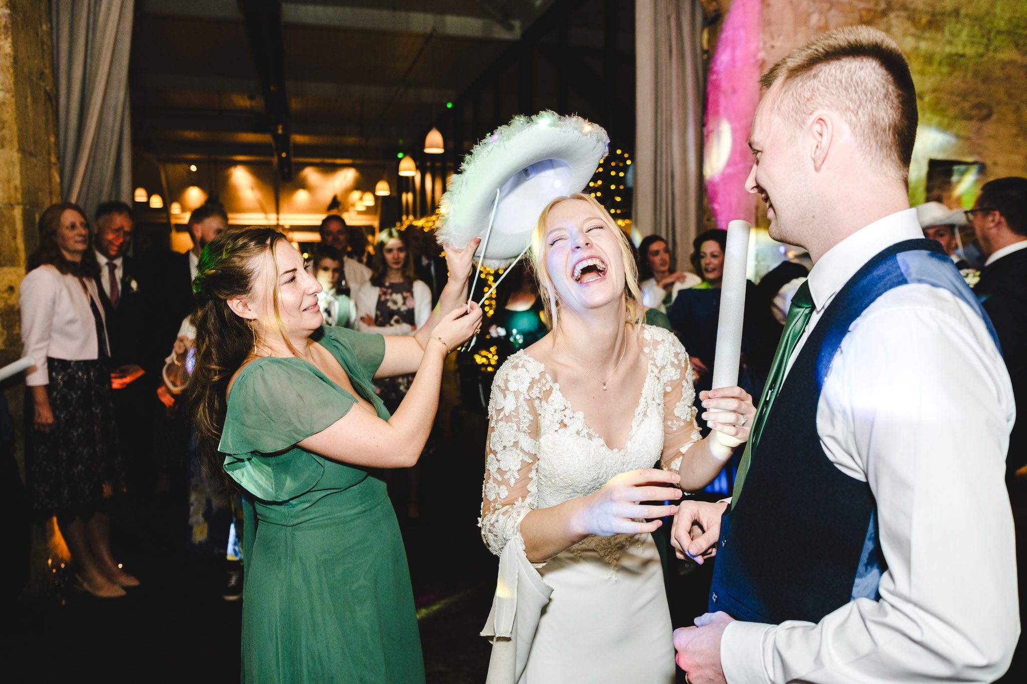 a bridesmaid giving the bride a cowboy hat