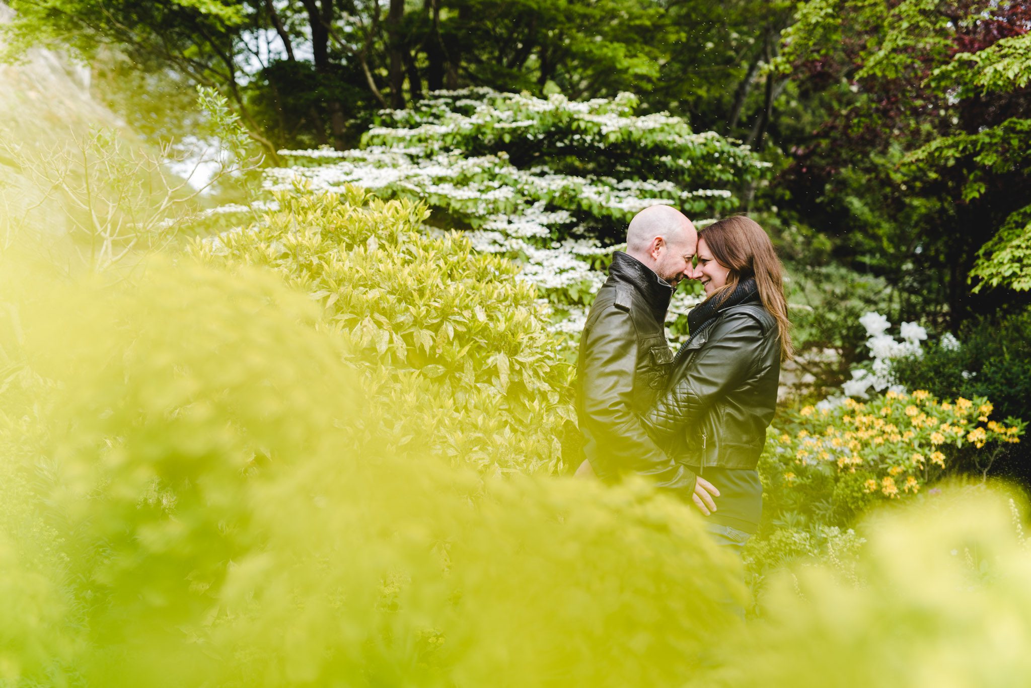 An engaged couple hugging amongst the trees